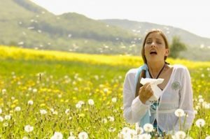 girl sneezing in field of flowers